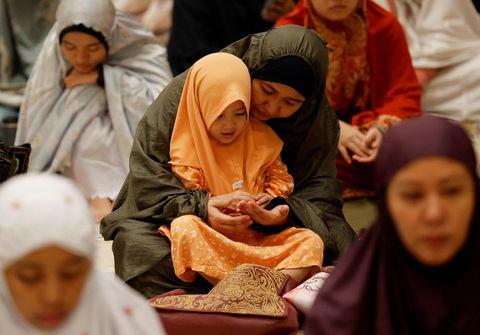 Hàng triệu tín đồ Hồi giáo bước vào tháng Ramadan, chia sẻ nỗi đau với người Gaza- Ảnh 2. Người mẹ hướng dẫn con gái đọc kinh trong giờ kinh Tarawih đầu tiên của tháng Ramadan tại thánh đường Hồi giáo Istiqlal (Indonesia) hôm 11-3 - Ảnh: REUTERS
