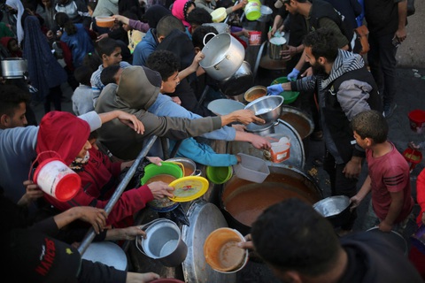 Hàng triệu tín đồ Hồi giáo bước vào tháng Ramadan, chia sẻ nỗi đau với người Gaza- Ảnh 9. Đám đông chen lấn để nhận thức ăn cho bữa Iftar từ một tổ chức từ thiện ở thành phố Rafah - Ảnh: AFP