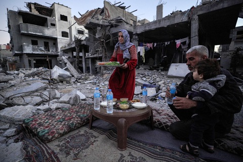 Hàng triệu tín đồ Hồi giáo bước vào tháng Ramadan, chia sẻ nỗi đau với người Gaza- Ảnh 6. Gia đình ông Al-Naji chuẩn bị ăn bữa Iftar - tức bữa ăn sau một ngày dài nhịn ăn - giữa đống đổ nát ở Deir el-Balah, miền trung Dải Gaza - Ảnh: AFP