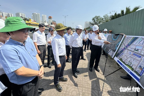 Bí thư Nguyễn Văn Nên thị sát hầm chui Nguyễn Văn Linh, cầu đường Nguyễn Khoái- Ảnh 1. Bí thư Nguyễn Văn Nên (thứ 2 từ phải sang) nghe báo cáo tiến độ dự án cầu đường Nguyễn Khoái - Ảnh: PHƯƠNG NHI
