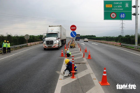 Lắp đinh phản quang, trụ cảnh báo nguy hiểm trên cao tốc Cam Lộ - La Sơn- Ảnh 3. Các tốp công nhân thuộc Ban quản lý dự án đường Hồ Chí Minh thi công lắp trụ cảnh báo nguy hiểm trên cao tốc Cam Lộ - La Sơn - Ảnh: N.L.