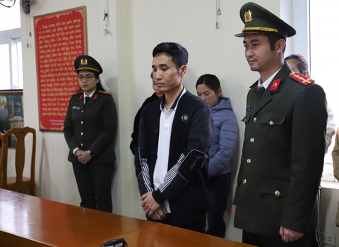 Khởi tố đường dây tổ chức đưa người vượt biên với giá hàng ngàn USD/người- Ảnh 1. Đỗ Trọng Anh (áo đen, giữa) tại cơ quan công an - Ảnh: CACC