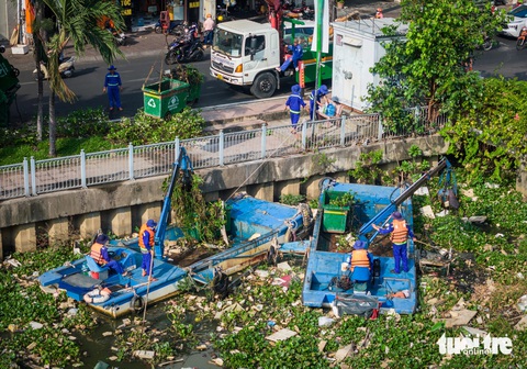 Công nhân 'đội nắng' gom 100 tấn rác kênh Nhiêu Lộc - Thị Nghè- Ảnh 6. Xe cẩu đậu trên đường Hoàng Sa (quận Tân Bình) để hỗ trợ các ca nô gom rác, cẩu lên xe ép