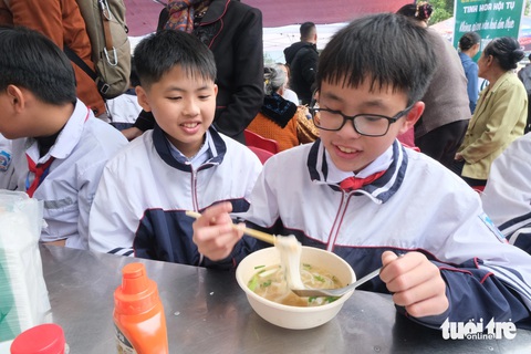 Nghệ nhân phở Vân Cù, Nam Định nấu nồi phở khổng lồ- Ảnh 1. Các em học sinh hào hứng thưởng thức phở làng Vân Cù, Nam Định - Ảnh: HÀ THANH