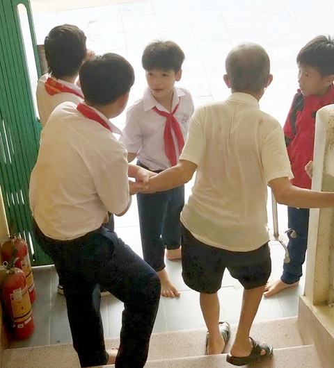 Các bạn nhỏ dìu cụ ông xuống cầu thang - Ảnh: Tác giả cung cấp Các bạn nhỏ dìu cụ ông xuống cầu thang - Ảnh: Tác giả cung cấp