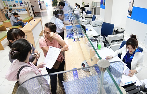 Khách hàng giao dịch tại một ngân hàng ở quận 1, TP.HCM - Ảnh: QUANG ĐỊNH Khách hàng giao dịch tại một ngân hàng ở quận 1, TP.HCM - Ảnh: QUANG ĐỊNH