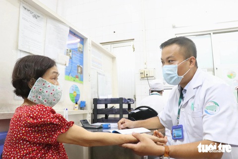 Hàng ngàn người đến Bệnh viện Bệnh nhiệt đới tiêm ngừa bệnh dại sau Tết- Ảnh 3. Bác sĩ CKII Danh Thơm - phó trưởng khoa khám bệnh Bệnh viện Bệnh nhiệt đới (TP.HCM) - khai thác thông tin, tư vấn người dân trước khi tiêm vắc xin dại - Ảnh: XUÂN MAI