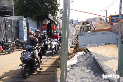 Đơn vị thi công khắc phục, lý giải việc lót tấm thép công trình đường Võ Văn Ngân- Ảnh 3. Cát, đá tại công trình phủ lên các tấm thép là điều khó tránh khỏi nên khi đi qua người dân phải hết sức cẩn thận - Ảnh: TIẾN QUỐC