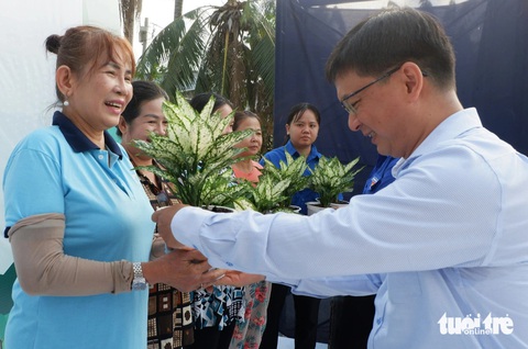 Hoa hậu Liên lục địa Lê Nguyễn Bảo Ngọc dọn rác Chủ nhật xanh- Ảnh 2. Trưởng Ban Dân vận Thành ủy TP.HCM Nguyễn Mạnh Cường (bên phải) trao cây xanh cho các hộ dân sống gần kênh Rạch Mướp - Ảnh: K.ANH