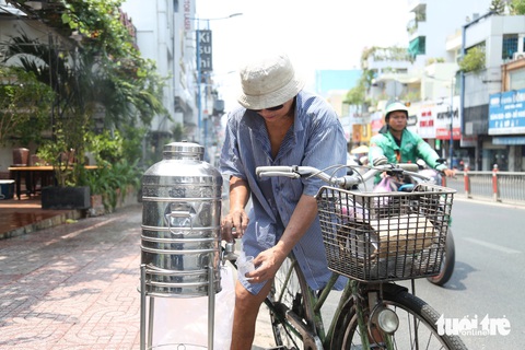 Người dân TP.HCM vật vã chống nắng, mát lòng với bình nước ven đường- Ảnh 4. Những bình nước ven đường nhận được sự ủng hộ của nhiều người dân, nhất là người lao động, tài xế xe công nghệ…