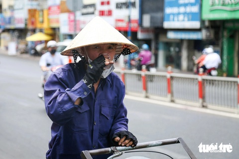 Người dân TP.HCM vật vã chống nắng, mát lòng với bình nước ven đường- Ảnh 6. Chú Thành (công nhân vệ sinh) uống nước từ bình nước miễn phí trên đường Phan Đình Phùng (quận Phú Nhuận)