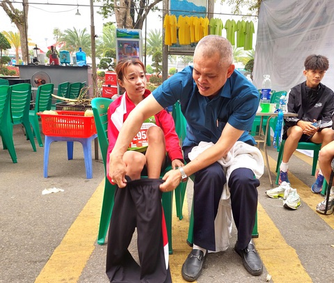 Hạ thân nhiệt nguy hiểm thế nào với dân chạy bộ?- Ảnh 2. VĐV Lê Thị Tuyết (trái) - nhà vô địch marathon quốc gia 2023 - rét run cầm cập sau khi cán đích tại Lai Châu tháng 3-2023. HLV Nguyễn Anh Tuấn phải ngay lập tức mặc quần áo cho Tuyết để giúp cô làm ấm cơ thể - Ảnh: K.X.