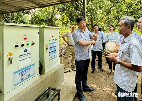 Làng thông minh ở Đồng Tháp trước dịch COVID-19 bây giờ ra sao?- Ảnh 2. Ông Lê Quốc Phong - bí thư Tỉnh ủy Đồng Tháp (bìa trái) - khảo sát hệ thống tưới nước thông minh vận hành bằng cảm biến trên ứng dụng điện thoại tại Tâm Quê hội quán tưới nước cho 0,5ha xoài - Ảnh: ĐẶNG TUYẾT