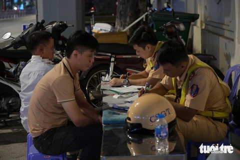Kiểm tra nồng độ cồn, người đàn ông vứt xe bỏ chạy vào hẻm mất hút- Ảnh 3. Sau nhiều giờ lập chốt, cảnh sát giao thông lập biên bản nhiều trường hợp vi phạm nồng độ cồn - Ảnh: MINH HÒA