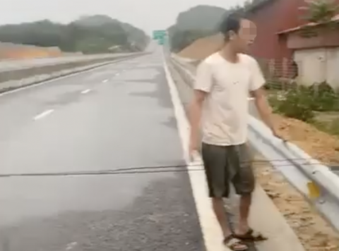 Bức xúc vì nhà ngập, người đàn ông căng dây chặn cao tốc- Ảnh 1. Người đàn ông căng dây chặn cao tốc Tuyên Quang - Phú Thọ - Ảnh: Q.C.
