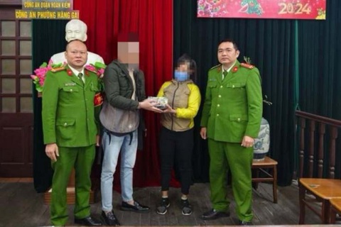 Nhặt được 105.000 USD, người phụ nữ mua phế liệu tưởng tiền âm phủ- Ảnh 1. Công an và người nhặt được tiền bàn giao lại tiền cho người bị đánh rơi - Ảnh: Công an cung cấp