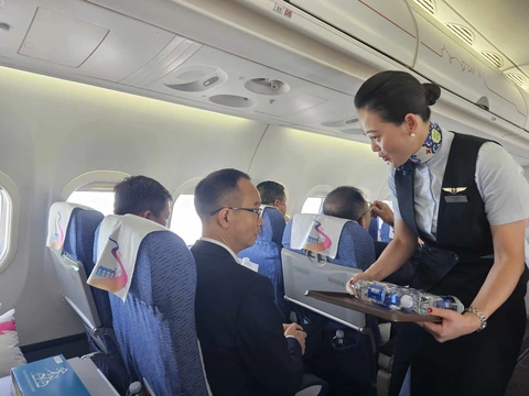 Hành khách Việt trải nghiệm máy bay 'made in China' tuyến TP.HCM - Đà Nẵng- Ảnh 4. Tiếp viên hãng Comac Express phục vụ nước cho hành khách - Ảnh: NGỌC ĐỨC