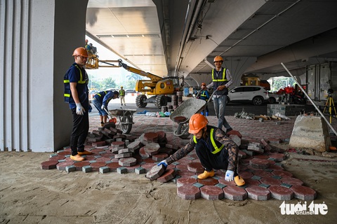 Hai nhánh cầu vượt trăm tỉ ở Hà Nội trước ngày thông xe- Ảnh 8. Các hạng mục đường sá, vỉa hè dưới gầm cầu cũng đang được hoàn thiện những công đoạn cuối - Ảnh: HỒNG QUANG