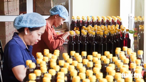 Hợp sức đưa cá chình suối, nước mắm, tiêu Phú Quốc đến gần khách hàng- Ảnh 1. Các công nhân ở nhà thùng làm nước mắm Phú Quốc nhộn nhịp đóng chai, gói quà bán cho du khách trong và ngoài nước - Ảnh: CHÍ CÔNG