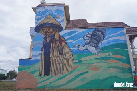 Họa sĩ vẽ graffiti trên tường nhà dân, phường xử phạt 2 triệu đồng, bắt xóa- Ảnh 1. Một bức tranh người nông dân trên cánh đồng được nhóm họa sĩ vẽ trên tường nhà dân - Ảnh: ĐOÀN NHẠN