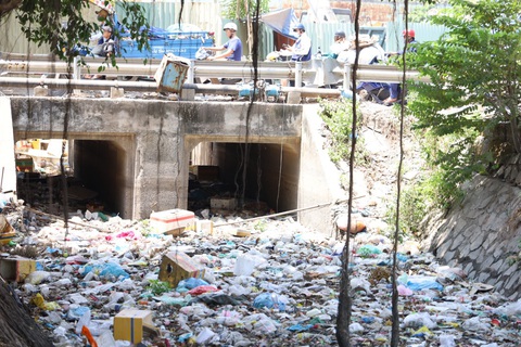Rác thải từ kênh 19-5 tràn qua kênh Tham Lương đang thi công - Ảnh: N.QUÝ
