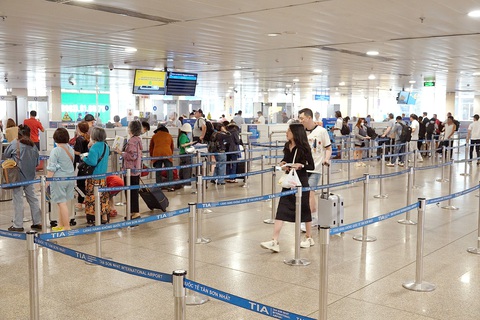 Thiếu máy bay do bảo dưỡng, đi lại ra sao?- Ảnh 5. Khách xếp hàng đợi soi hành lý tại sân bay Tân Sơn Nhất vào chiều 20-3 - Ảnh: T.T.D.