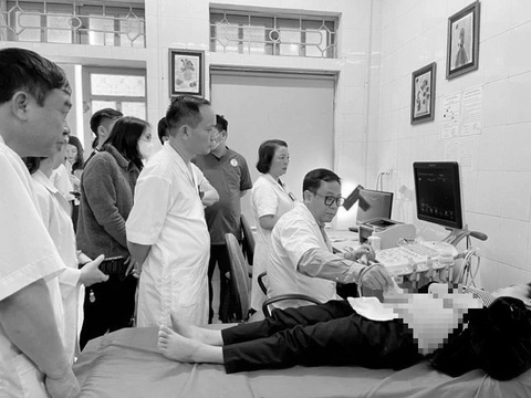 Chuyến đi đặc biệt của y bác sĩ Hải Phòng- Ảnh 1. PGS Vũ Văn Tâm (người ngồi) hướng dẫn siêu âm sản phụ khoa cho y bác sĩ ở Trung tâm Y tế huyện Yên Bình, Yên Bái - Ảnh: HỒNG HÀ