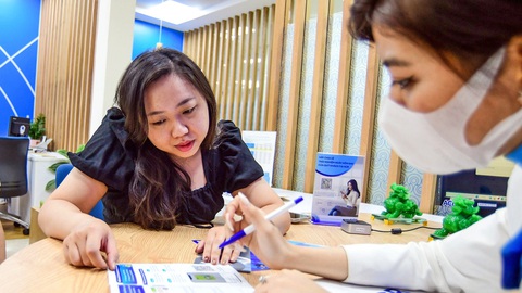 Từ ngày 1-7: Chuyển tiền trên 10 triệu phải xác thực bằng khuôn mặt, vân tay- Ảnh 1. Khách hàng được tư vấn thực hiện giao dịch qua app - Ảnh: QUANG ĐỊNH