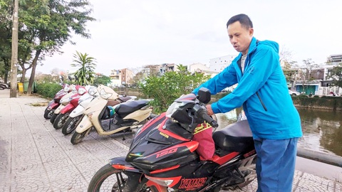 Quy định đậu xe máy khác thường ở Huế: Dân chưa phục- Ảnh 1. Nhiều hàng quán ở TP Huế cử người túc trực để quay đầu xe cho khách do quy định yêu cầu đậu xe trên vỉa hè phải quay đầu xe ra ngoài đường của TP Huế - Ảnh: NHẬT LINH