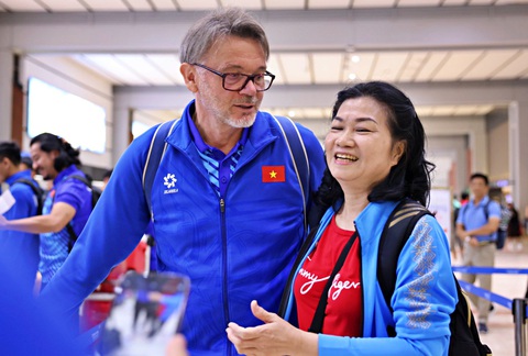 Tuyển Việt Nam buồn bã rời Indonesia- Ảnh 2. HLV Troussier chụp ảnh cùng cổ động viên Việt Nam ở sân bay - Ảnh: VIỆT PHONG