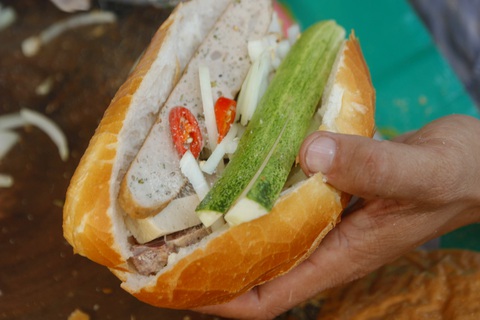 Một ổ bánh mì cụ Lý đầy đủ gồm 5 loại chả, dưa leo, ớt, hành tây, nước tương - Ảnh: HỒ LAM Một ổ bánh mì cụ Lý đầy đủ gồm 5 loại chả, dưa leo, ớt, hành tây, nước tương - Ảnh: HỒ LAM