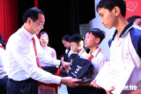 6.200 suất học bổng 'Cho em đến trường' hỗ trợ học sinh Đồng Nai- Ảnh 3. Phó chủ tịch UBND tỉnh Đồng Nai Võ Văn Phi trao học bổng, cặp sách cho các em học sinh - Ảnh: A LỘC