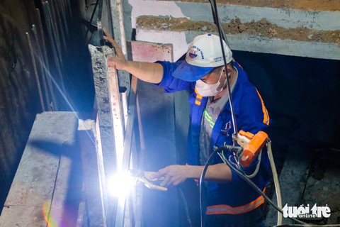 Đường Võ Văn Ngân thi công xuyên đêm, nỗ lực hoàn thành trước ngày 30-4- Ảnh 2. Công nhân làm việc miệt mài bên dưới một cống hộp - Ảnh: TIẾN QUỐC