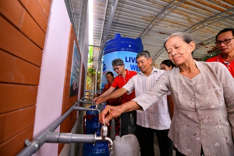 Keppel đưa máy lọc nước nhiễm mặn đến với người dân Bến Tre và Trà Vinh- Ảnh 2. Người dân lấy nước sạch từ hệ thống máy lọc nước