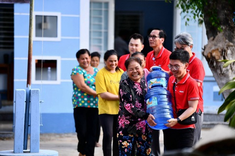 Keppel đưa máy lọc nước nhiễm mặn đến với người dân Bến Tre và Trà Vinh- Ảnh 4. Các tình nguyện viên Keppel hỗ trợ người dân địa phương lấy nước