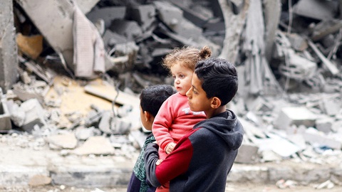 Lệnh ngừng bắn và sự rạn nứt giữa Mỹ với Israel- Ảnh 1. Những đứa trẻ Palestine đứng nhìn một ngôi nhà đổ nát sau loạt không kích của Israel tại Rafah, phía nam Dải Gaza, ngày 24-3 - Ảnh: Reuters