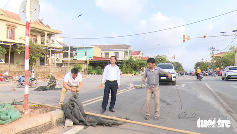 Người dân dỡ rào chắn đường 70 tỉ đồng- Ảnh 1. Người dân tháo dỡ các vật cản rào đường Hùng Vương sau khi được chủ tịch UBND huyện Hướng Hóa vận động - Ảnh: HOÀNG TÁO