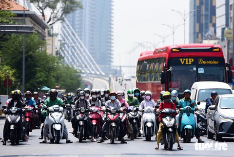 TP.HCM nóng hầm hập, nhiệt độ cảm nhận lên tới 40 độ C- Ảnh 9. Mặt đường khô ran, hơi nóng tạt hừng hực vào mặt khi lái xe gắn máy trên đường