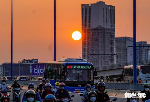 Ngắm hoàng hôn ở TP.HCM: Mặt trời như lòng đỏ trứng nhuộm cam cả một khoảng trời- Ảnh 6. Đến 18h, Mặt trời đã lặn xuống thấp - Ảnh: CHÂU TUẤN