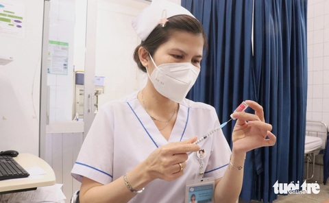 Khó biết trẻ bị chó mèo cào cắn nhẹ, phòng bệnh dại thế nào?- Ảnh 1. Nhân viên y tế Bệnh viện Bệnh nhiệt đới (TP.HCM) chuẩn bị vắc xin phòng bệnh dại tiêm cho người dân bị chó cắn - Ảnh: XUÂN MAI