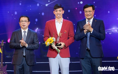 Khối lượng tập luyện của VĐV đua xe đạp và bơi lội được ví với chu vi Trái đất- Ảnh 1. Ông Đặng Hà Việt (bìa phải) và phó tổng giám đốc Thông tấn xã Việt Nam Nguyễn Tuấn Hùng trao giải cho Gương mặt thể thao của năm Nguyễn Huy Hoàng - Ảnh: NAM TRẦN