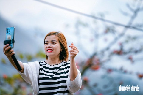 Hoa gạo thắp lửa trên cao nguyên đá Đồng Văn- Ảnh 4. Du khách dừng chân check-in cùng hoa gạo bên đường