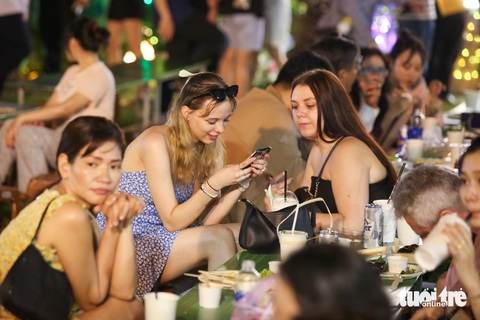 Khách Tây hào hứng với lễ hội văn hóa, ẩm thực Việt- Ảnh 1. Zora (trái) cùng bạn xem lại những bức ảnh kỷ niệm chụp tại lễ hội