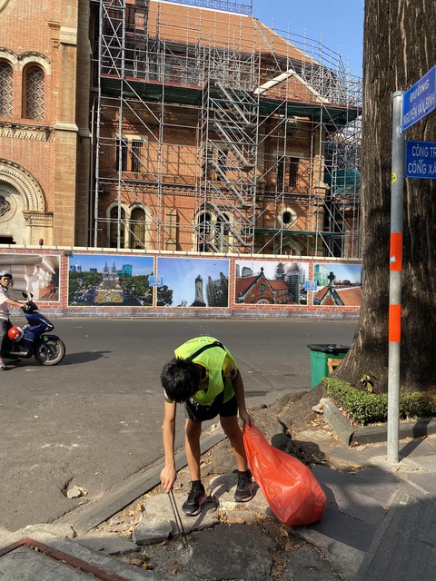 'Thấy bạn trẻ Nhật đến nhà mình nhặt rác, khi ấy mặt tôi có cảm giác như bị dày lên'- Ảnh 1. Cậu bé Nikki 12 tuổi đến từ Nhật Bản đang lượm rác sáng chủ nhật 24-3 - Ảnh: HUY THỌ
