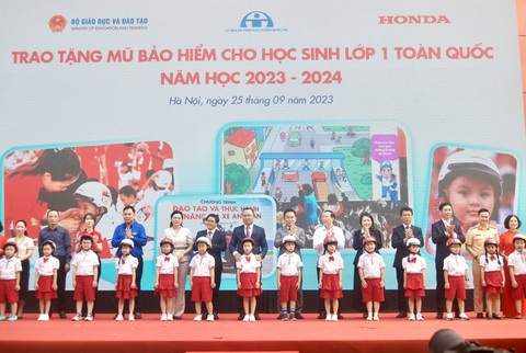 Honda tổng kết trao tặng mũ bảo hiểm cho học sinh lớp một- Ảnh 1. Các đại biểu trao tặng mũ bảo hiểm cho các em học sinh lớp 1 Trường tiểu học Phú Đô