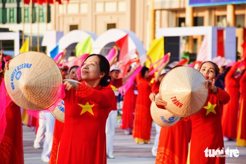 Màn biểu diễn múa trong trang phục áo dài quốc kì và nón lá - Ảnh: TRẦN HOÀI Màn biểu diễn múa trong trang phục áo dài quốc kỳ và nón lá - Ảnh: TRẦN HOÀI
