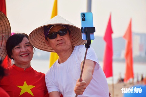 Du khách chụp ảnh cùng các diễn viên quần chúng - Ảnh: TRẦN HOÀI Du khách chụp ảnh cùng các diễn viên - Ảnh: TRẦN HOÀI