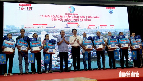 Trao 200 phần quà thắp sáng đèn trên biển cho ngư dân Đà Nẵng- Ảnh 1. Nguyên Phó thủ tướng thường trực Trương Hòa Bình và ông Trần Chí Cường, phó chủ tịch UBND TP Đà Nẵng, trao quà cho ngư dân - Ảnh: TRƯỜNG TRUNG
