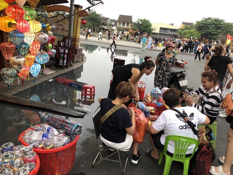 Khó tin cảnh khách lội bì bõm dưới vũng nước thải đen ngòm ở phố cổ Hội An- Ảnh 2. Khách ngồi mua sắm, ăn uống ngay bên khúc đường ngập lênh láng nước thải - Ảnh: C.T.