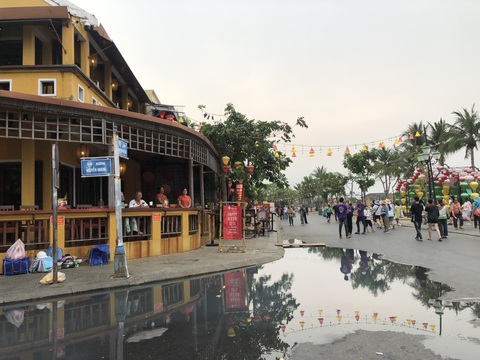 Khó tin cảnh khách lội bì bõm dưới vũng nước thải đen ngòm ở phố cổ Hội An- Ảnh 1. Khách du lịch ngồi bên nhà hàng bất đắc dĩ "ngắm một dòng sông khác" ngoài sông Hoài là vũng nước thải - Ảnh: C.T.